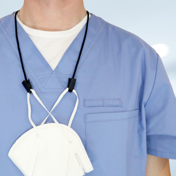 Close-up of a person wearing blue medical scrubs with a white face mask hanging around their neck, secured by a USA Made Adjustable Double Clip Lanyard - Woven Nylon Neck Hanger with 2 Bulldog Clips for convenience.
