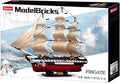 The USS Constitution 1794 Navy Frigate comes in a large, colorful box featuring a glossy image of the finished ship sailing on a stylized blue ocean and sky, with three detailed masts, off-white sails, and a red-and-black textured hull. The logo appears at the top left, while bold text along the bottom lists the model name, subtitle, and 1,118-piece count. A small illustration in the bottom left corner depicts a sailor holding a weight.