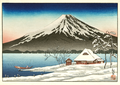 Winter landscape with small snow-covered building on the coast and view of Mount Fuji