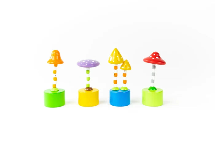 The image shows four colorful wooden mushroom push puppets. Each has a striped stem standing on a bright base, topped with a mushroom cap in different shapes and colors, all decorated with cheerful polka dots.